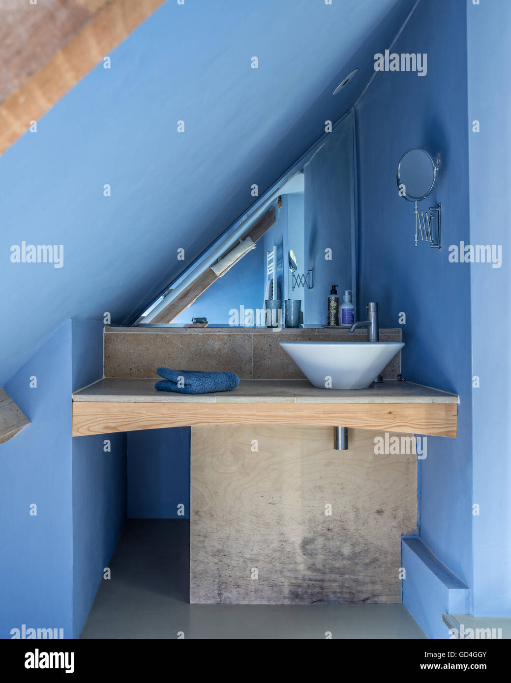 Blue bathroom built under the eaves with purpose built wood units Stock Photo