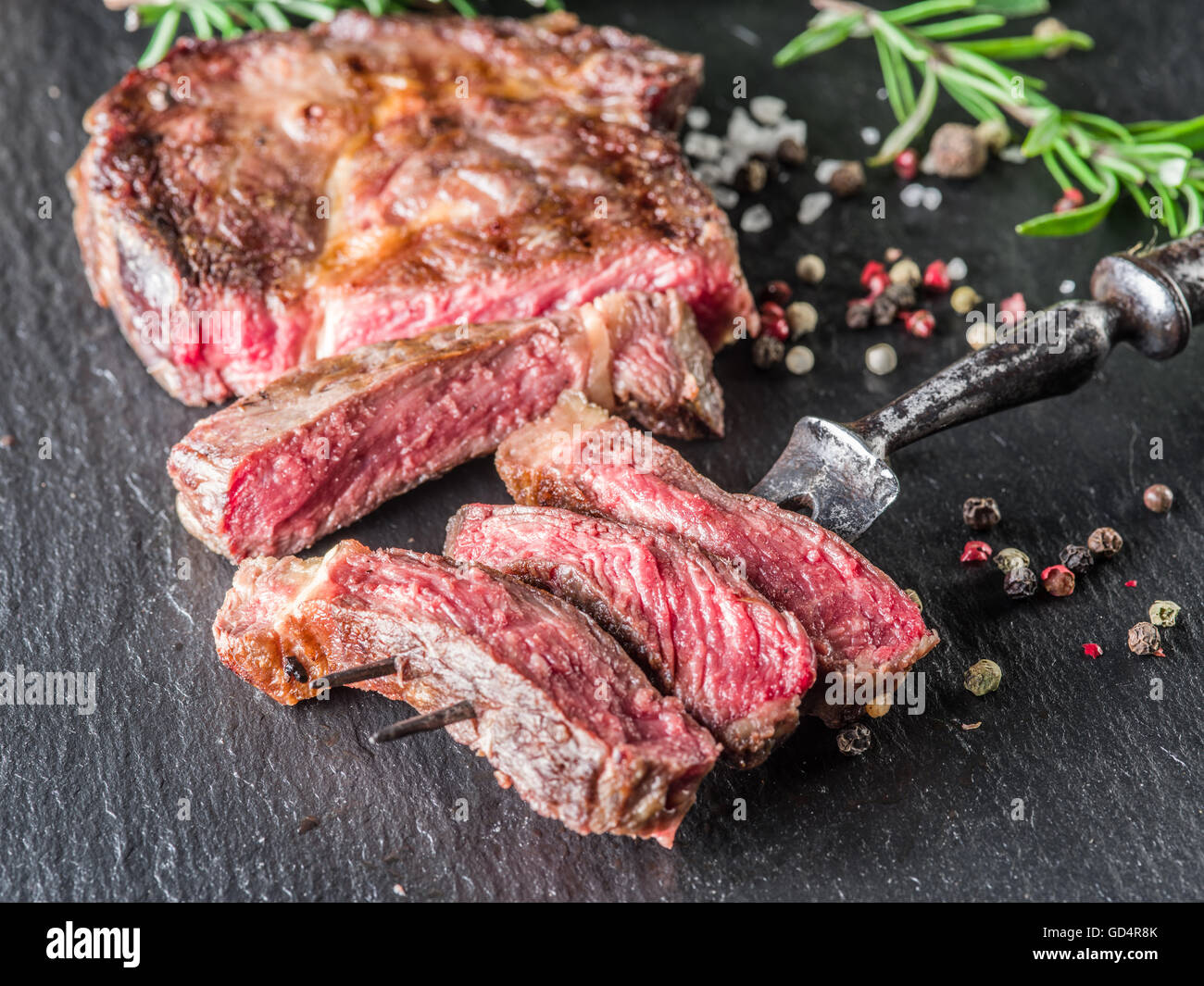 Medium Rib eye steak with spices on the graphite tray Stock Photo - Alamy