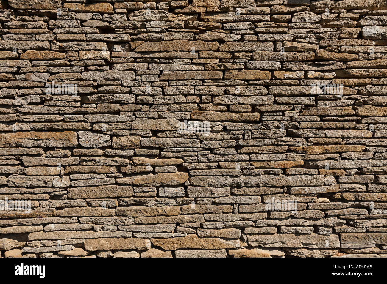 A stone wall of a fence built of old stones Stock Photo