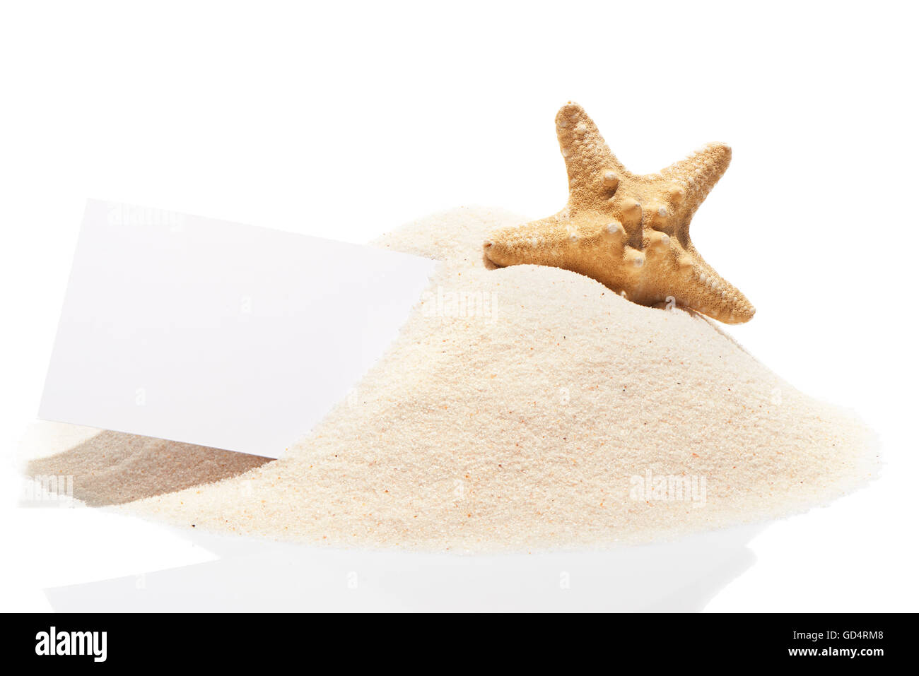 Blank white visit card with starfish on pile of beach sand, isolated on white background Stock Photo