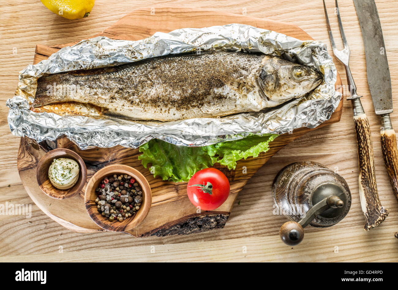 Grilled sea bass fish on the wooden tray. Stock Photo