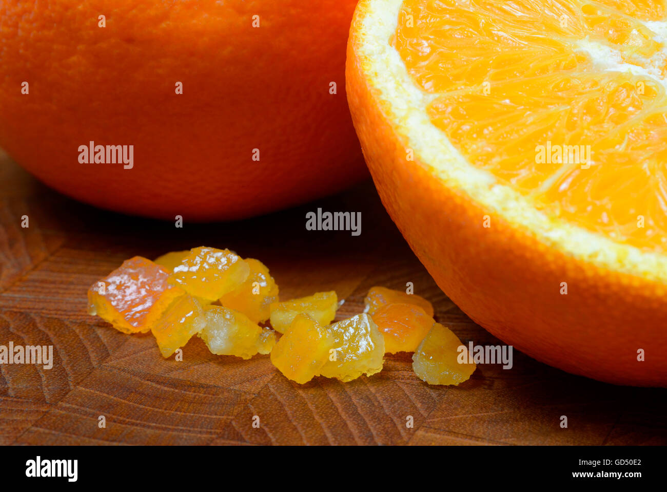 Orangeat, kandierte Orangenschalen, Orangenschalenwuerfel und Orangen Stock Photo