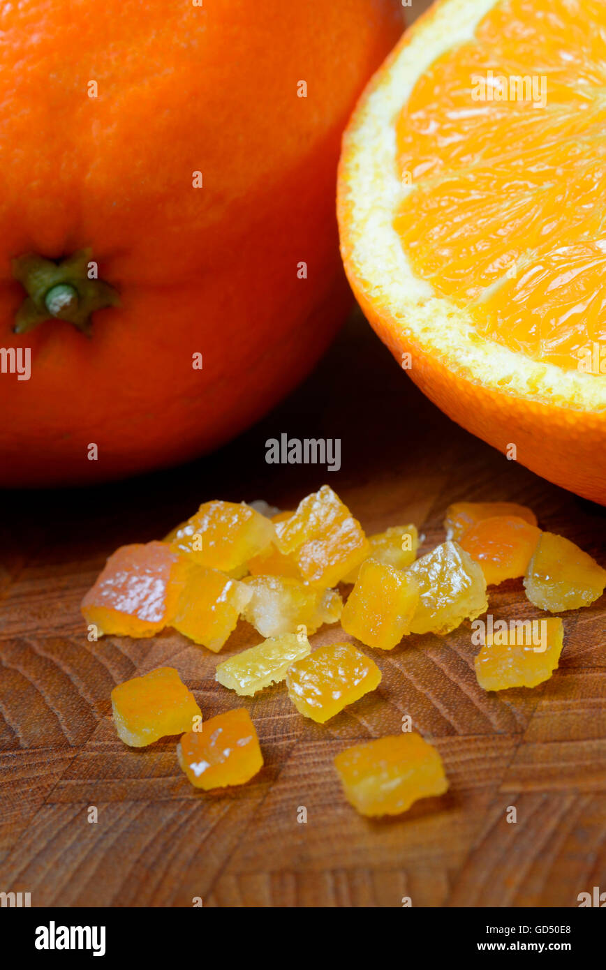 Orangeat, kandierte Orangenschalen, Orangenschalenwuerfel und Orangen Stock Photo