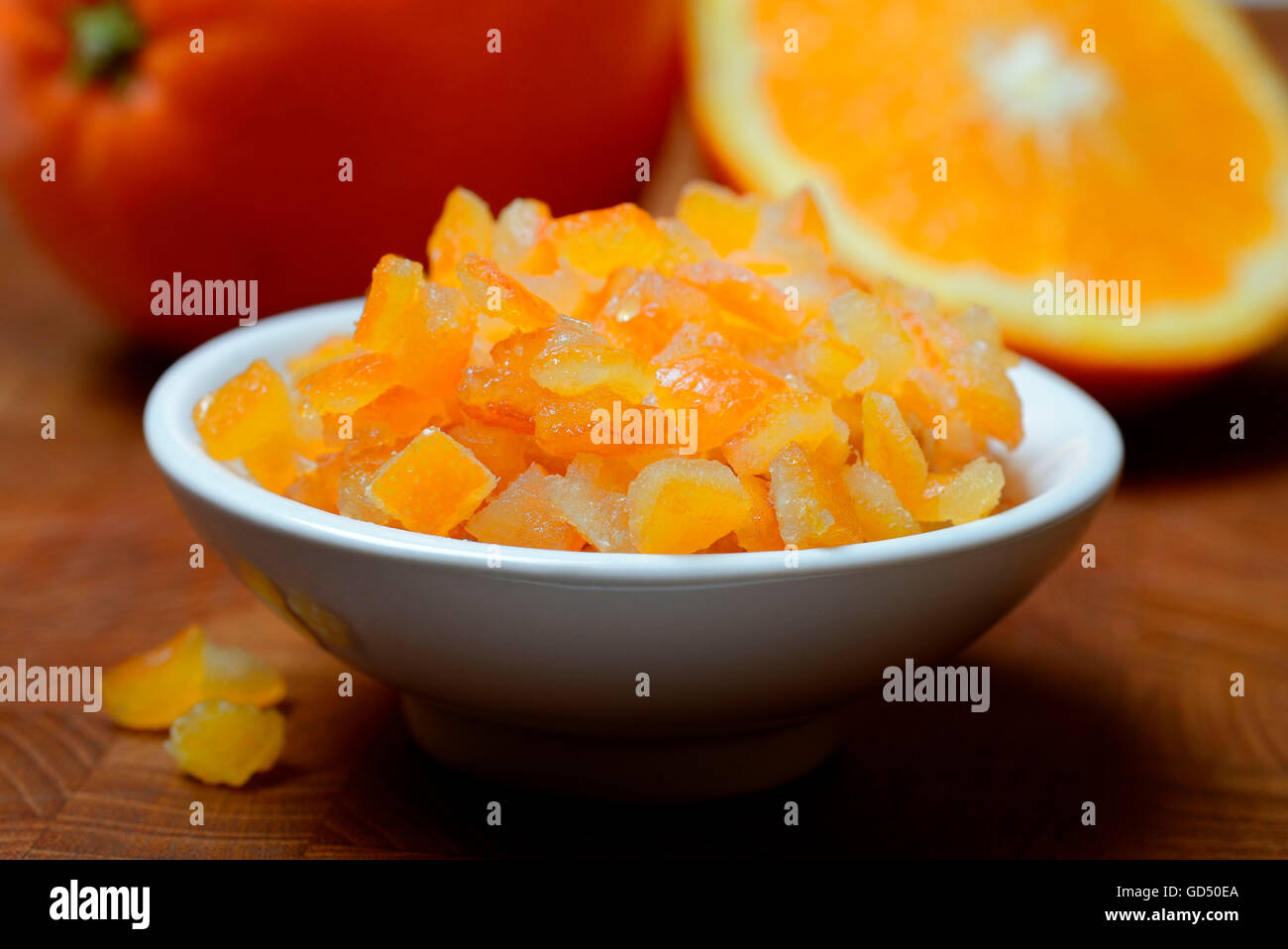Orangeat, kandierte Orangenschalen in Schale, Orangenschalenwuerfel und Orangen, Apfelsine Stock Photo