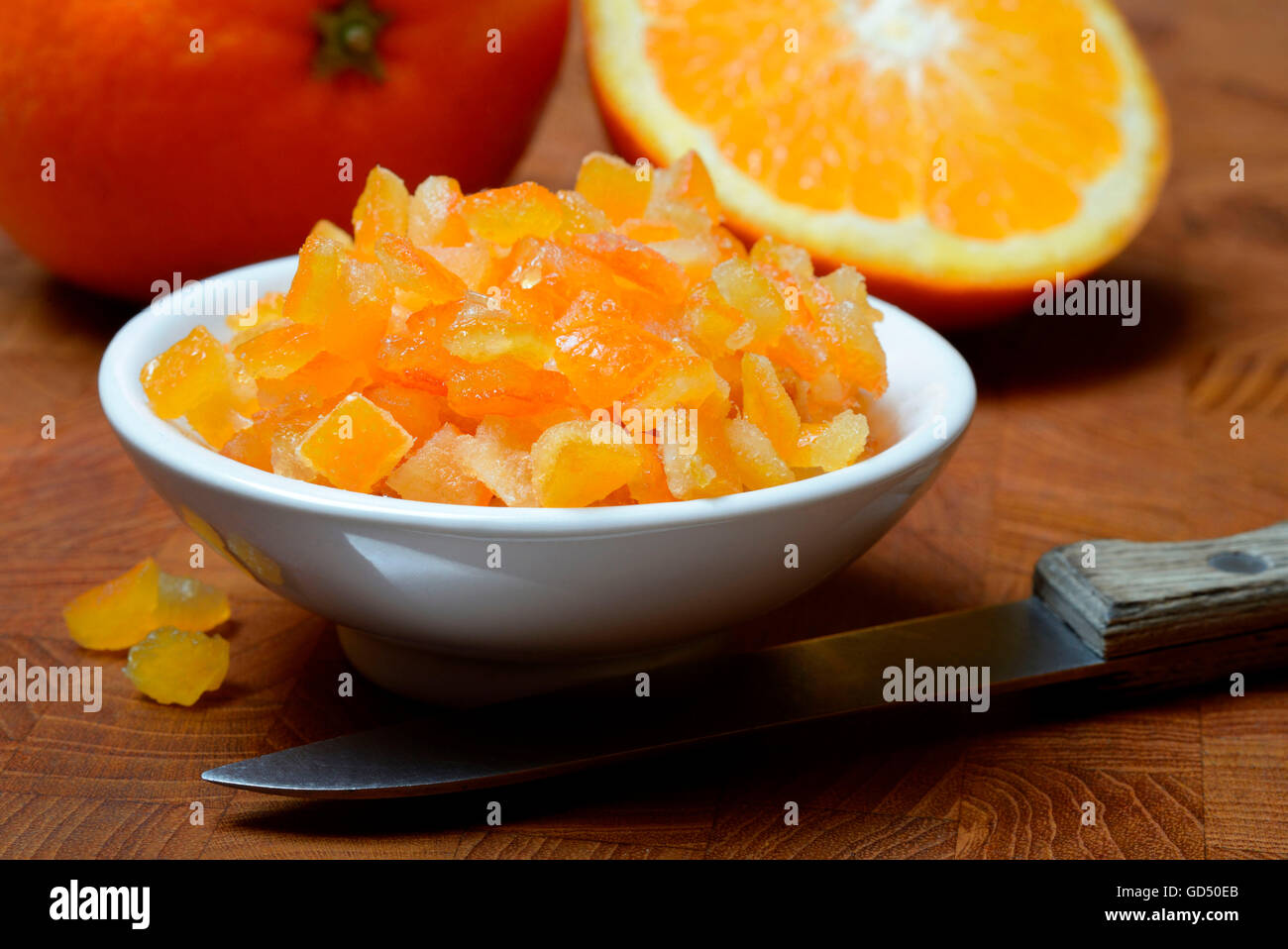 Orangeat, kandierte Orangenschalen in Schale, Orangenschalenwuerfel und Orangen, Apfelsine Stock Photo