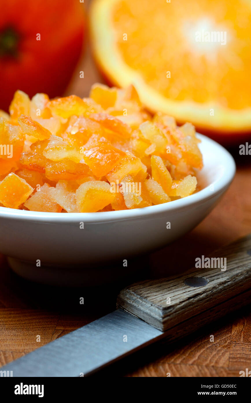 Orangeat, kandierte Orangenschalen in Schale, Orangenschalenwuerfel und Orangen, Apfelsine Stock Photo