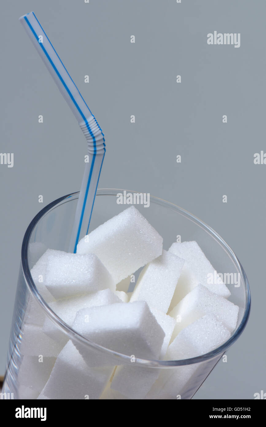 Zuckerwuerfel in Trinkglas mit Strohhalm, Zuckerkonsum, Zuckerverbrauch, weisser Zucker, Ruebenzucker, Rübenzucker Stock Photo