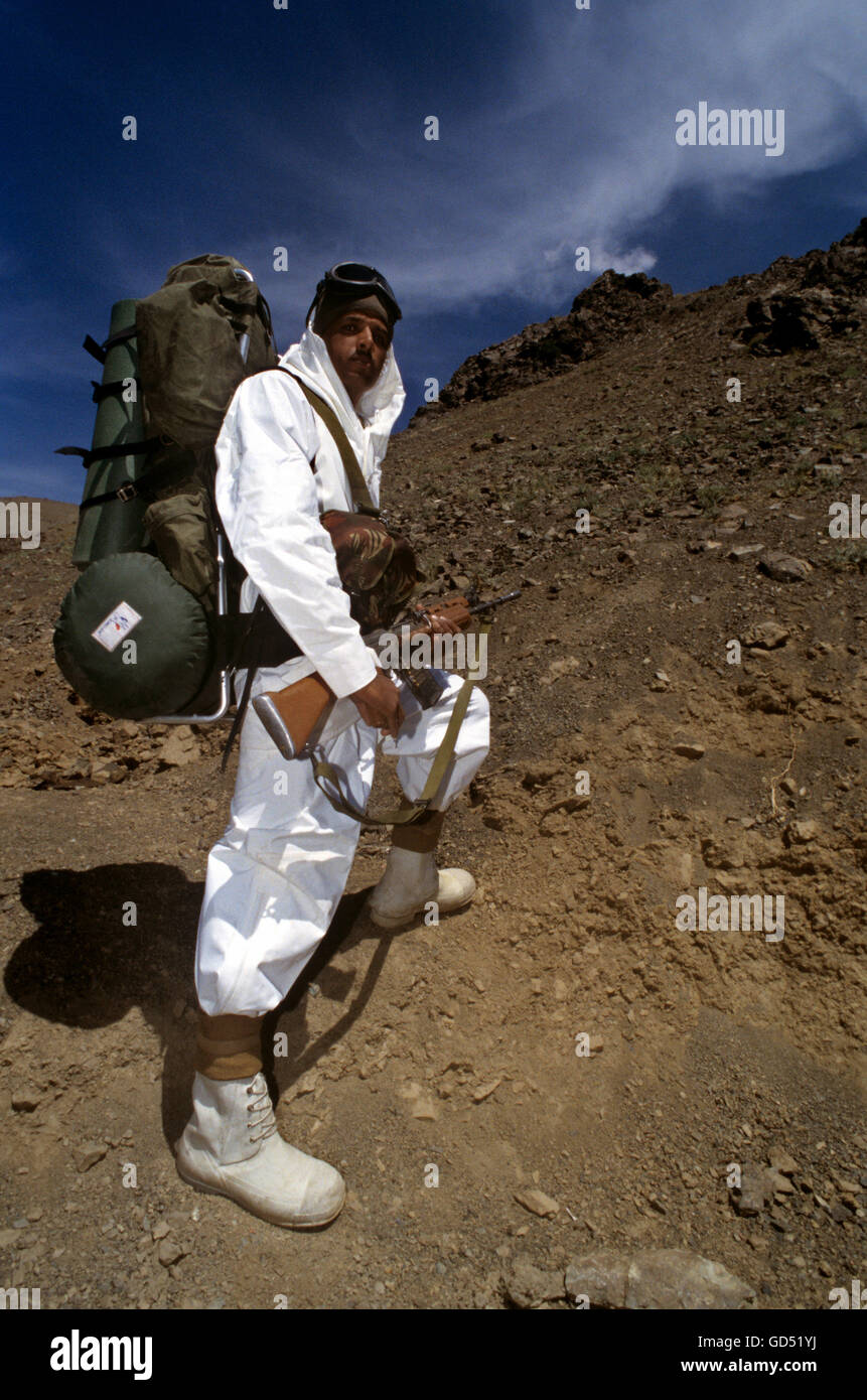 Soldier climbing mountain Stock Photo