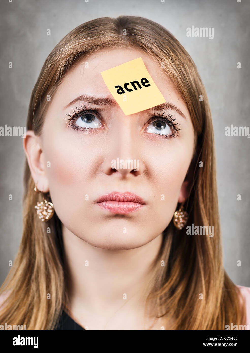 Confused woman with a sticker on her forehead Stock Photo