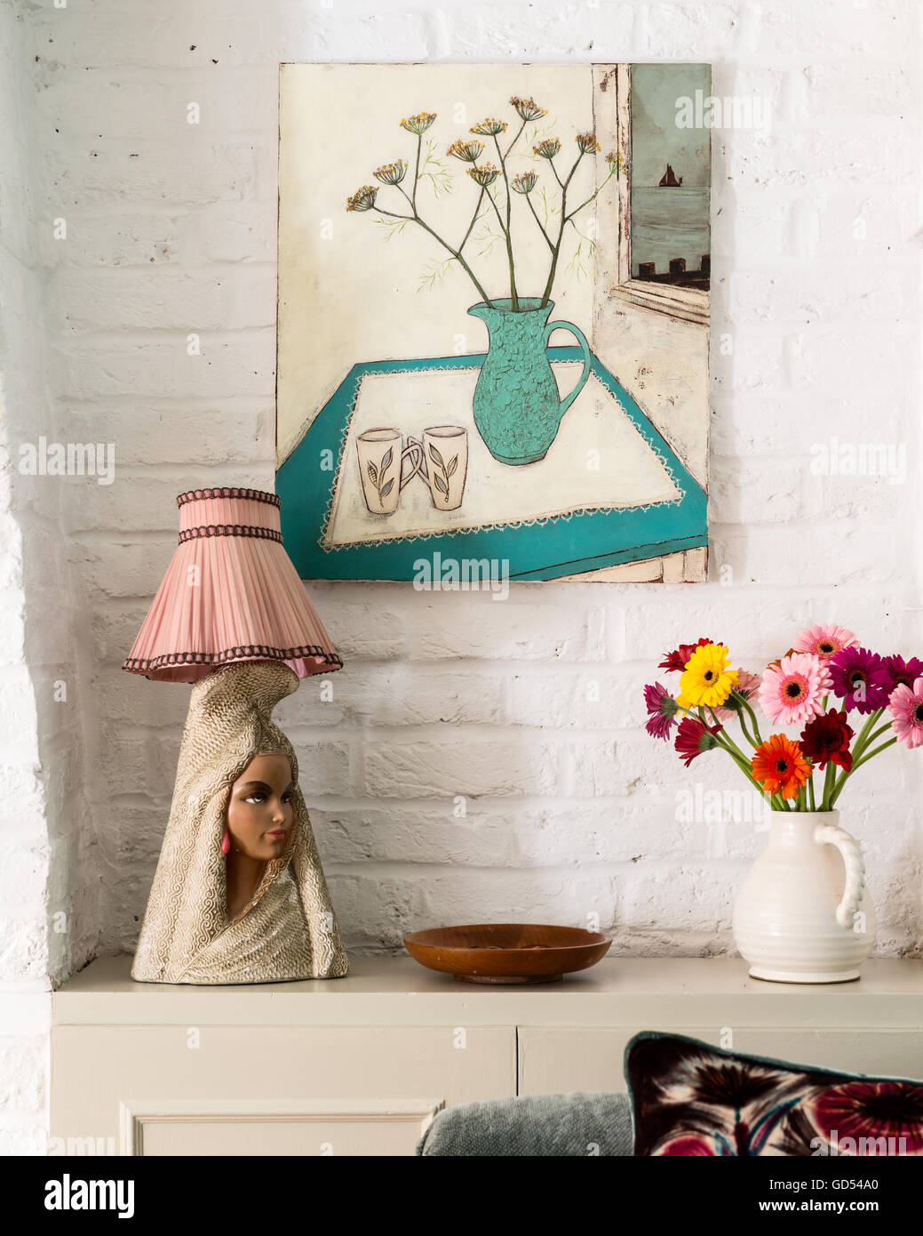Retro lamp stand on surface with vase of flowers Stock Photo