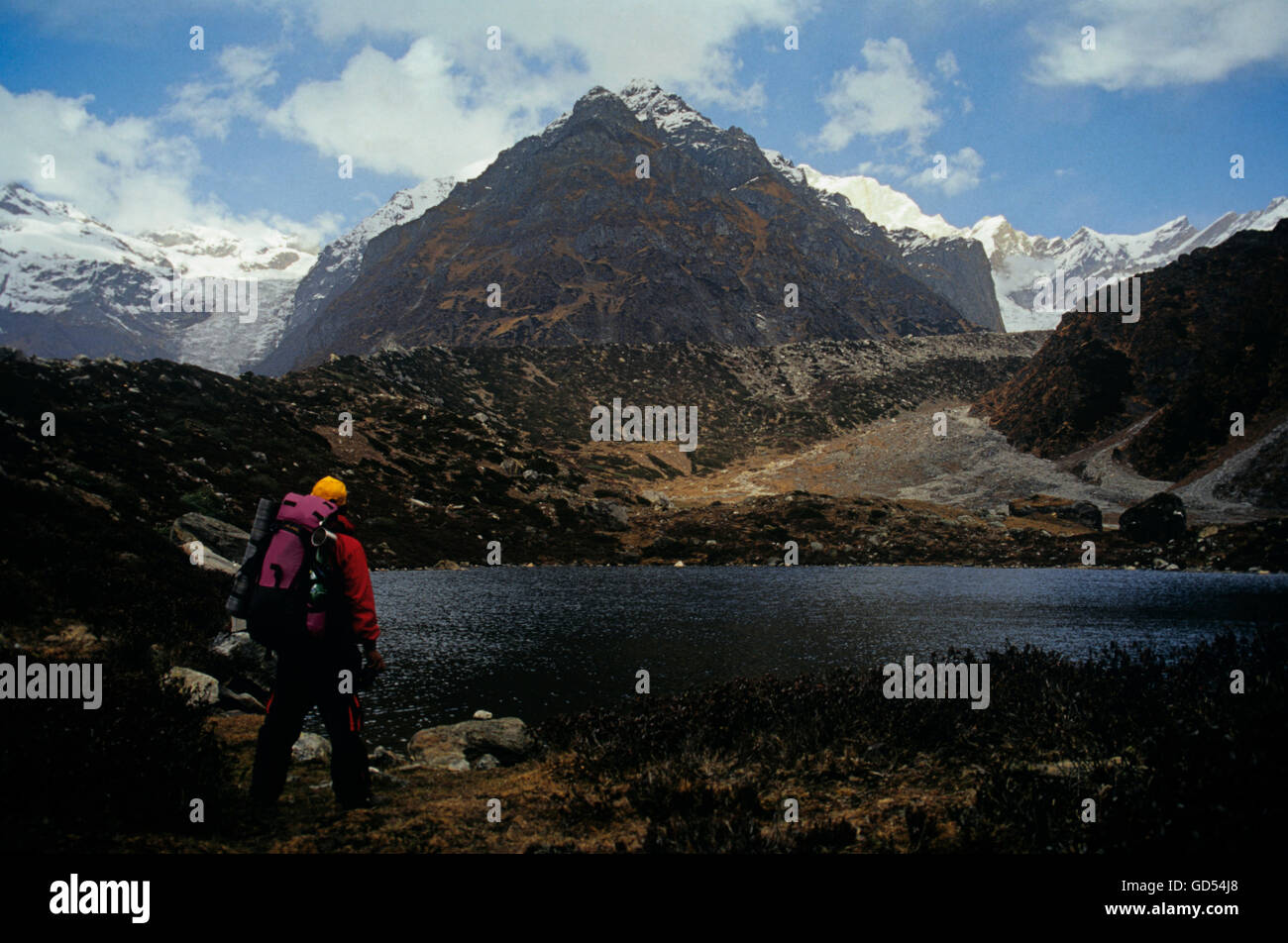 A trekker standing near a lake Stock Photo