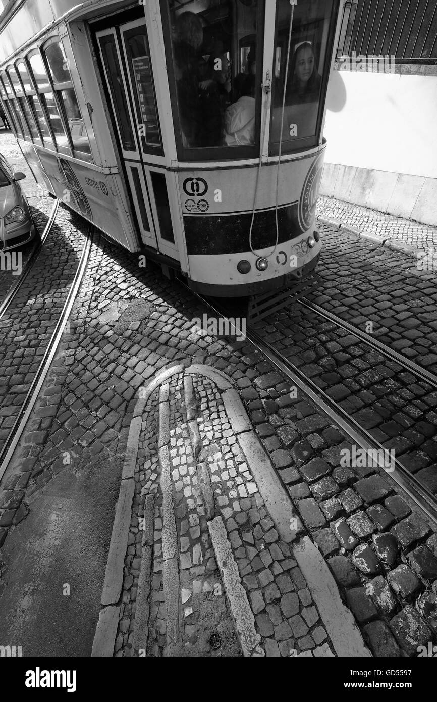 Trams Lisbon with sunlight casting patterns and shadows on the cobbles and tram tracks Stock Photo