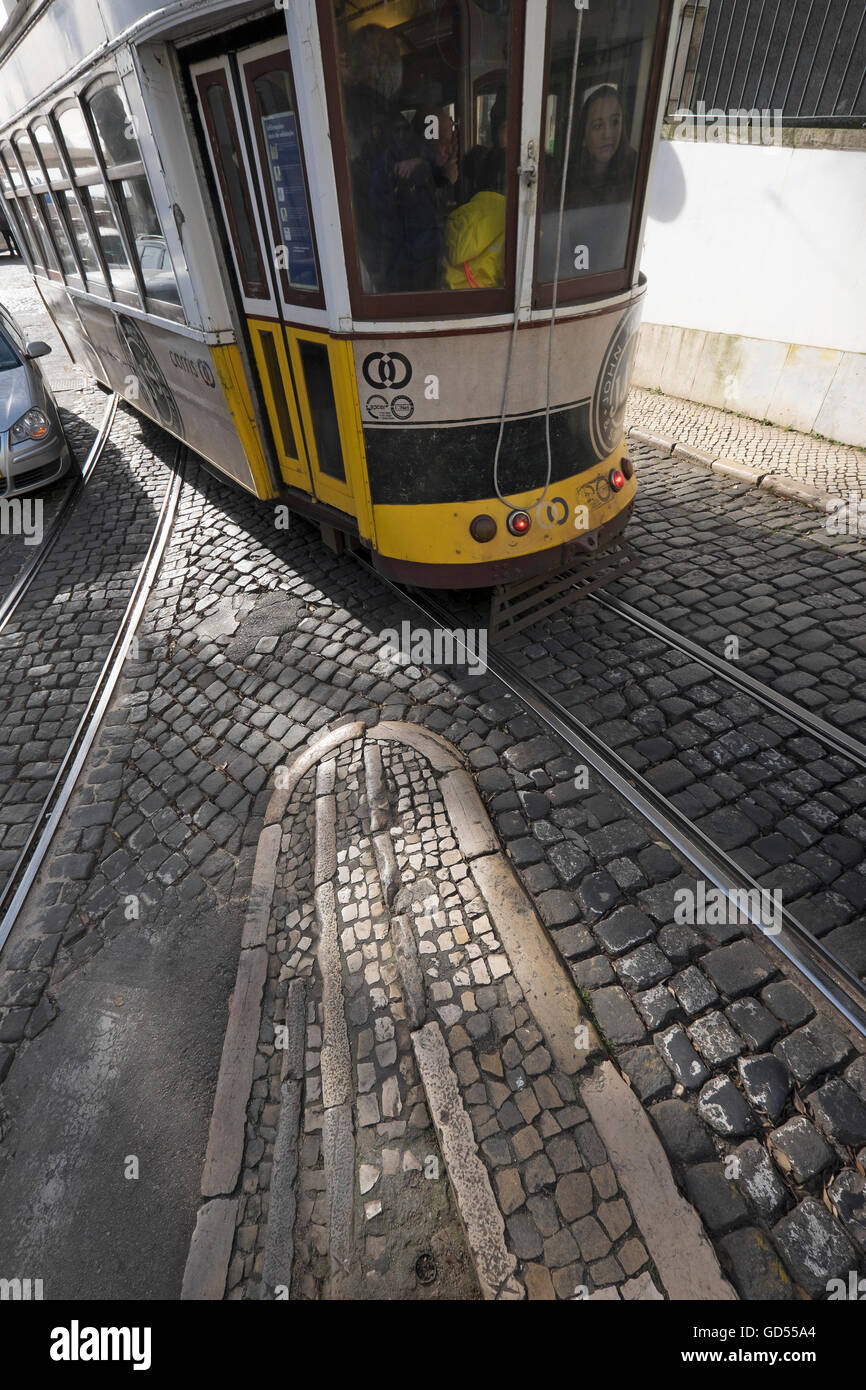 Trams Lisbon with sunlight casting patterns and shadows on the cobbles and tram tracks Stock Photo