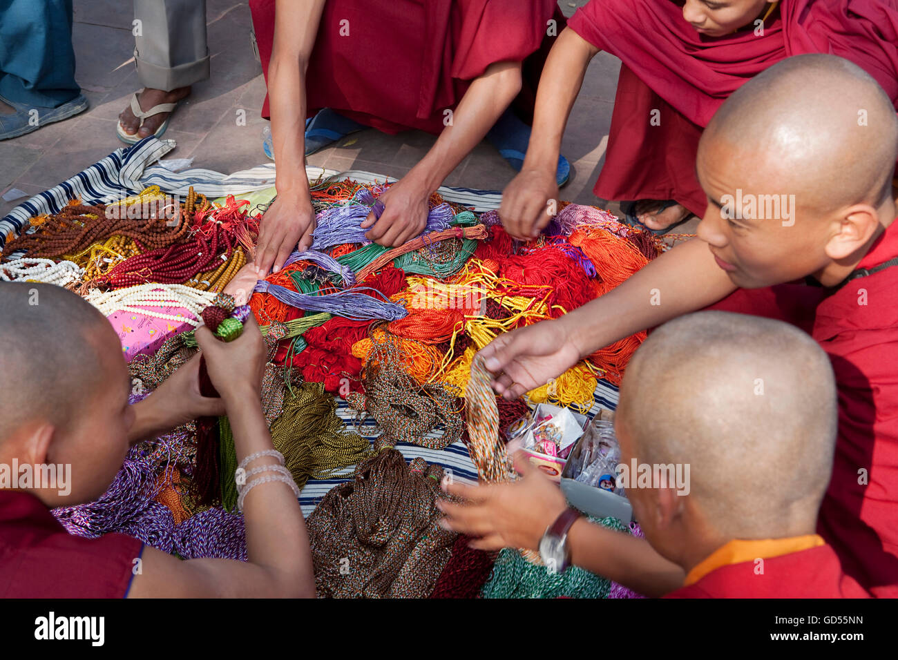 Monks buying coloured threads Stock Photo - Alamy