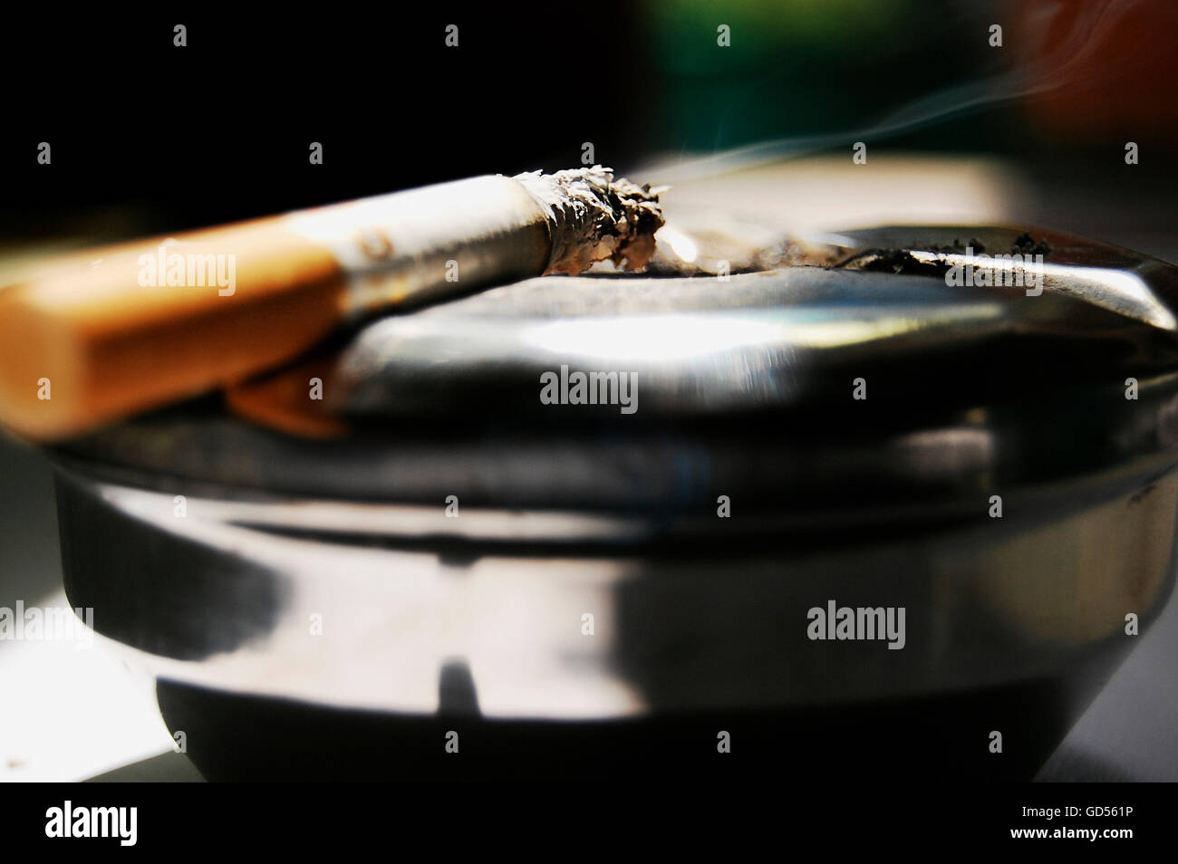 A halfsmoked cigarette on an ashtray Stock Photo Alamy