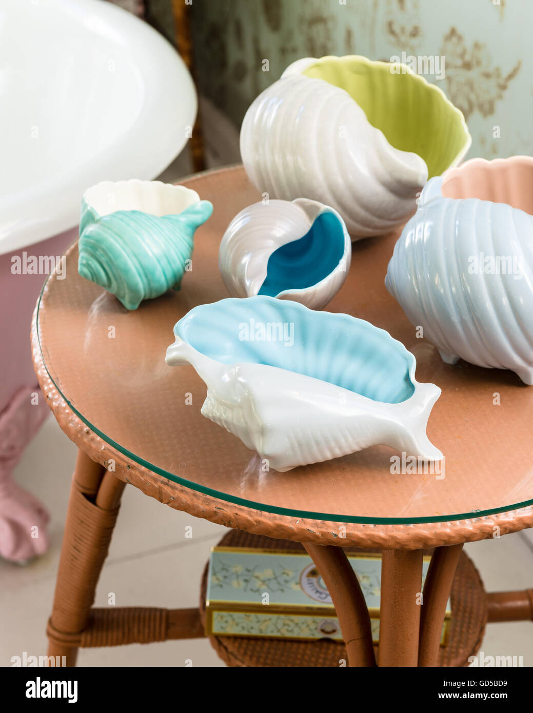 Pastel hued ceramic shells on side table Stock Photo