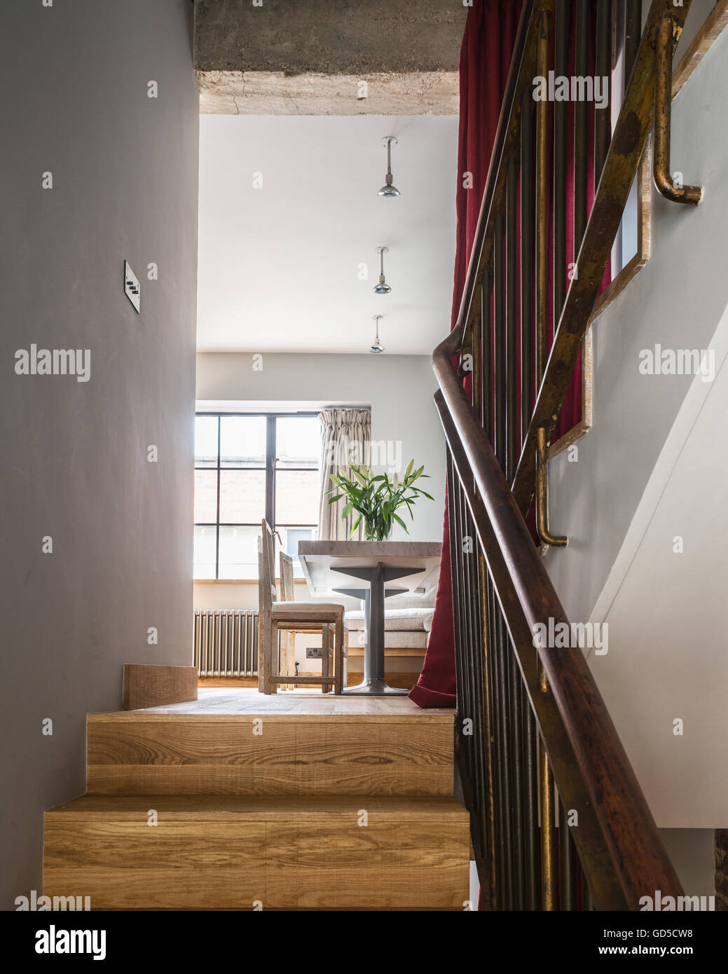 Oak floored staircase leading up to open plan kitchen dining area Stock Photo
