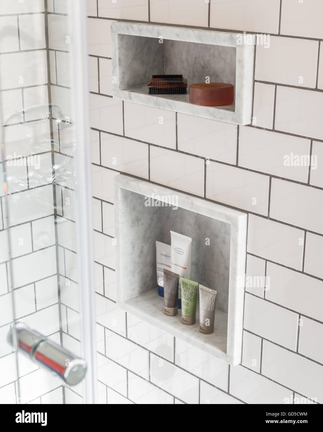 Subway tiling and inbuilt shelf alcoves in shower cubicle Stock Photo