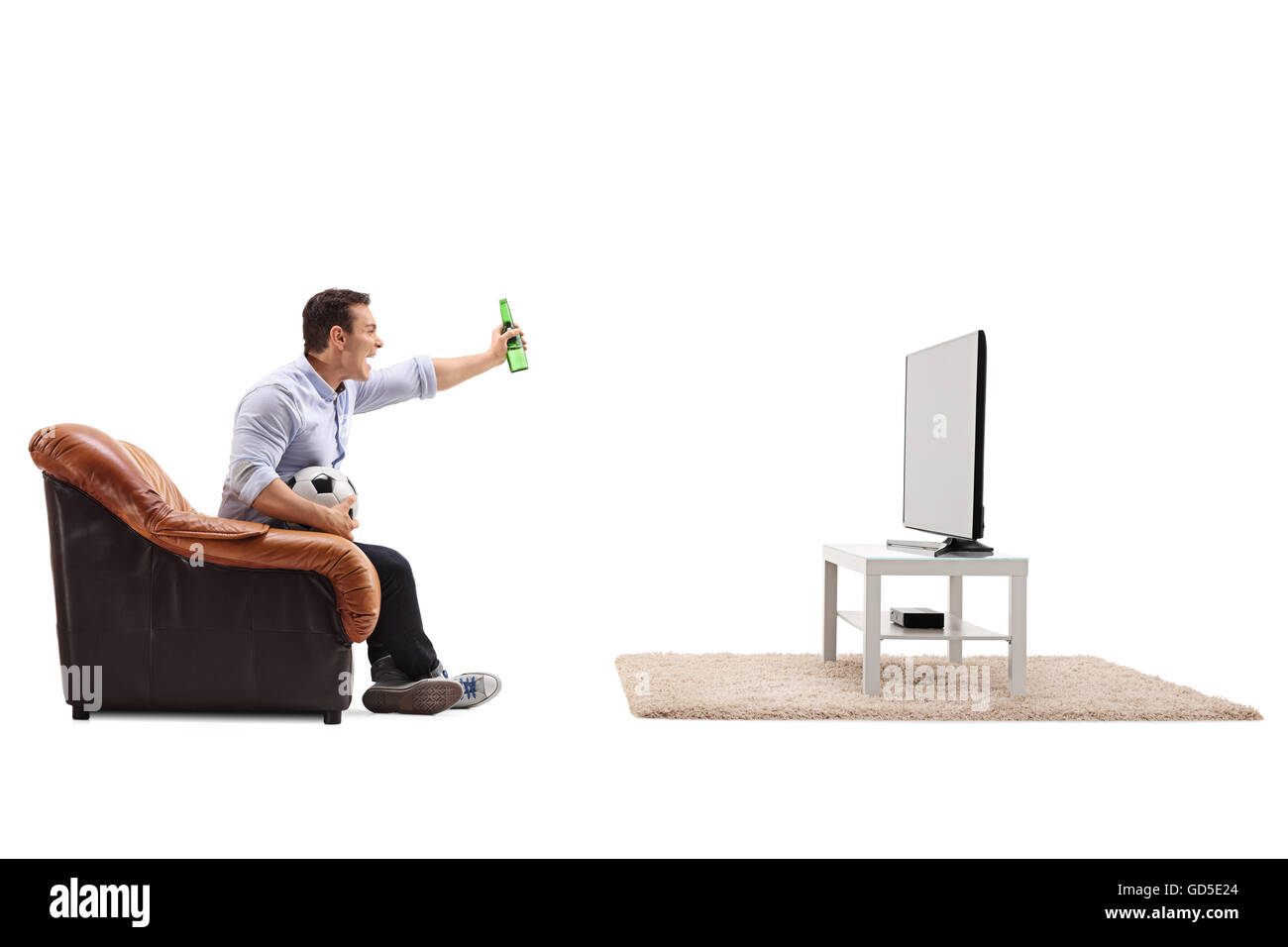 Joyful guy watching football on TV and celebrating with a beer isolated on white background Stock Photo