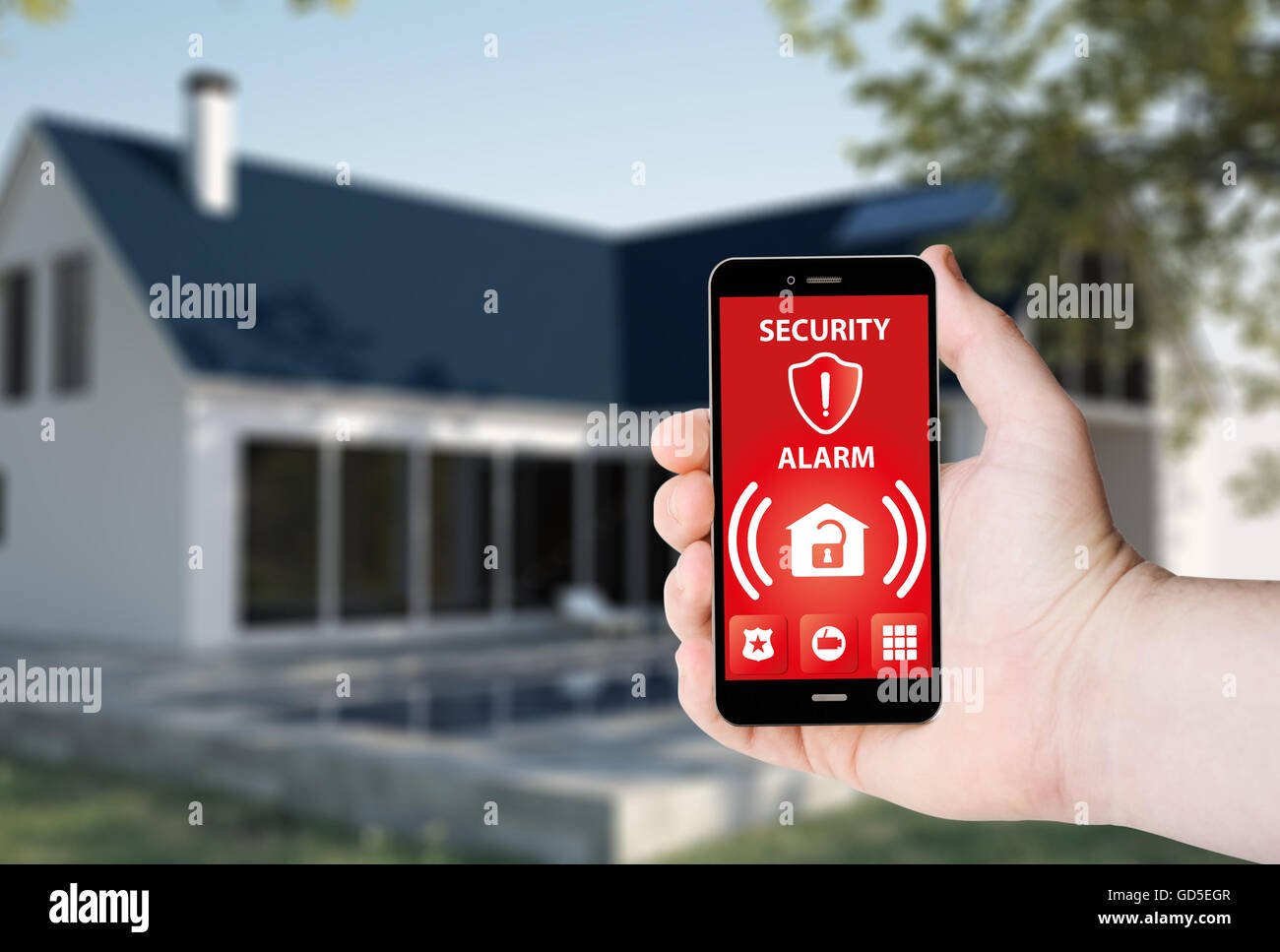 Hand hold a phone with security alarm app on a screen on the background