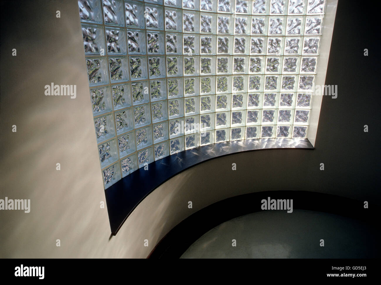 Sun streaming through block glass wall in a stairwell, American College