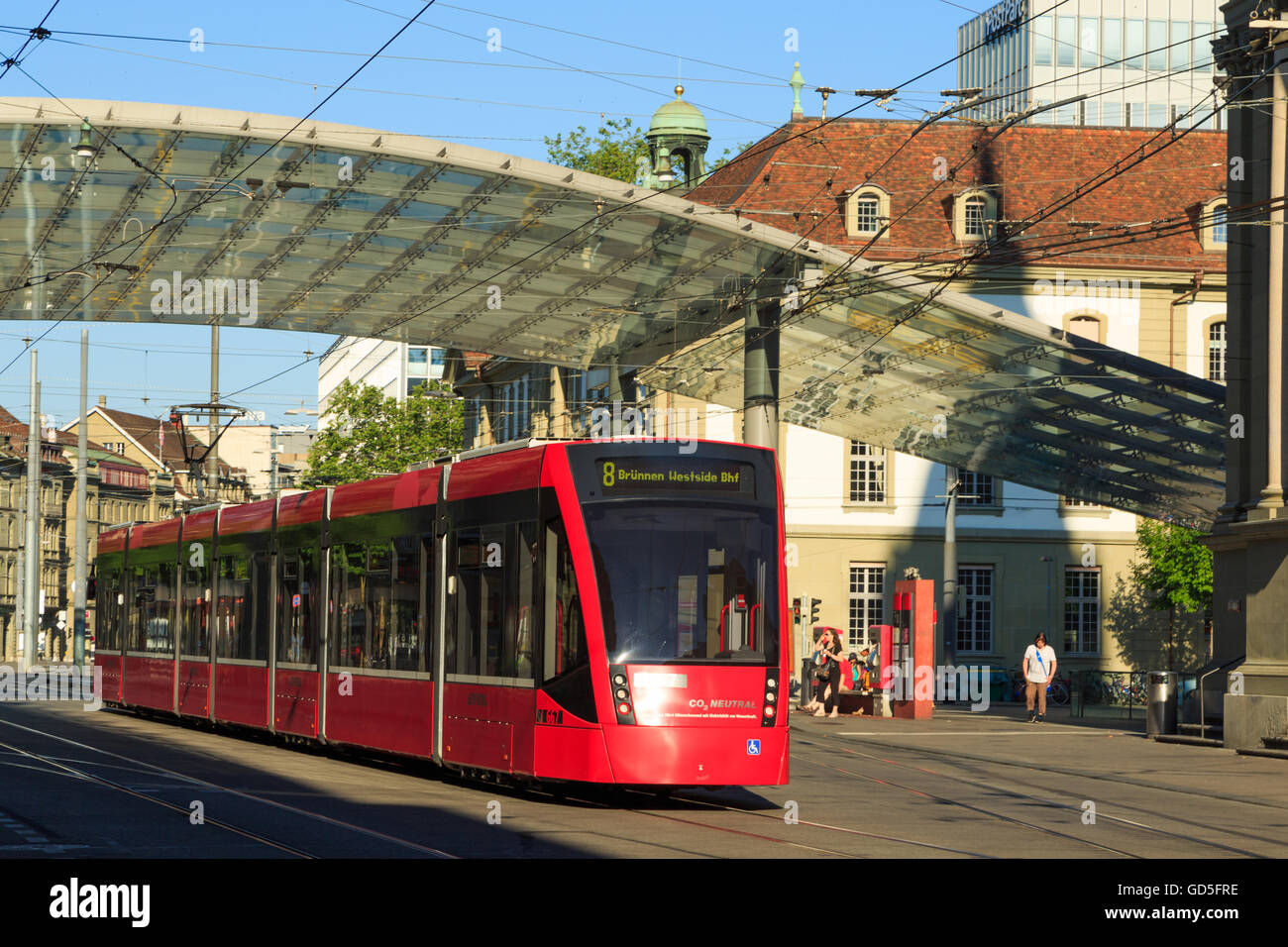 A photograph of a red tram near the main train station in Bern, Switzerland. Stock Photo