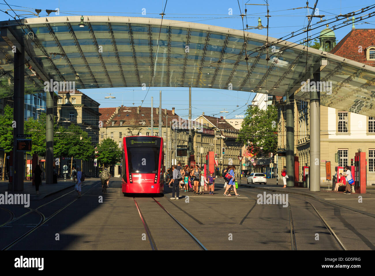 A photograph of a red tram near the main train station in Bern, Switzerland. Stock Photo