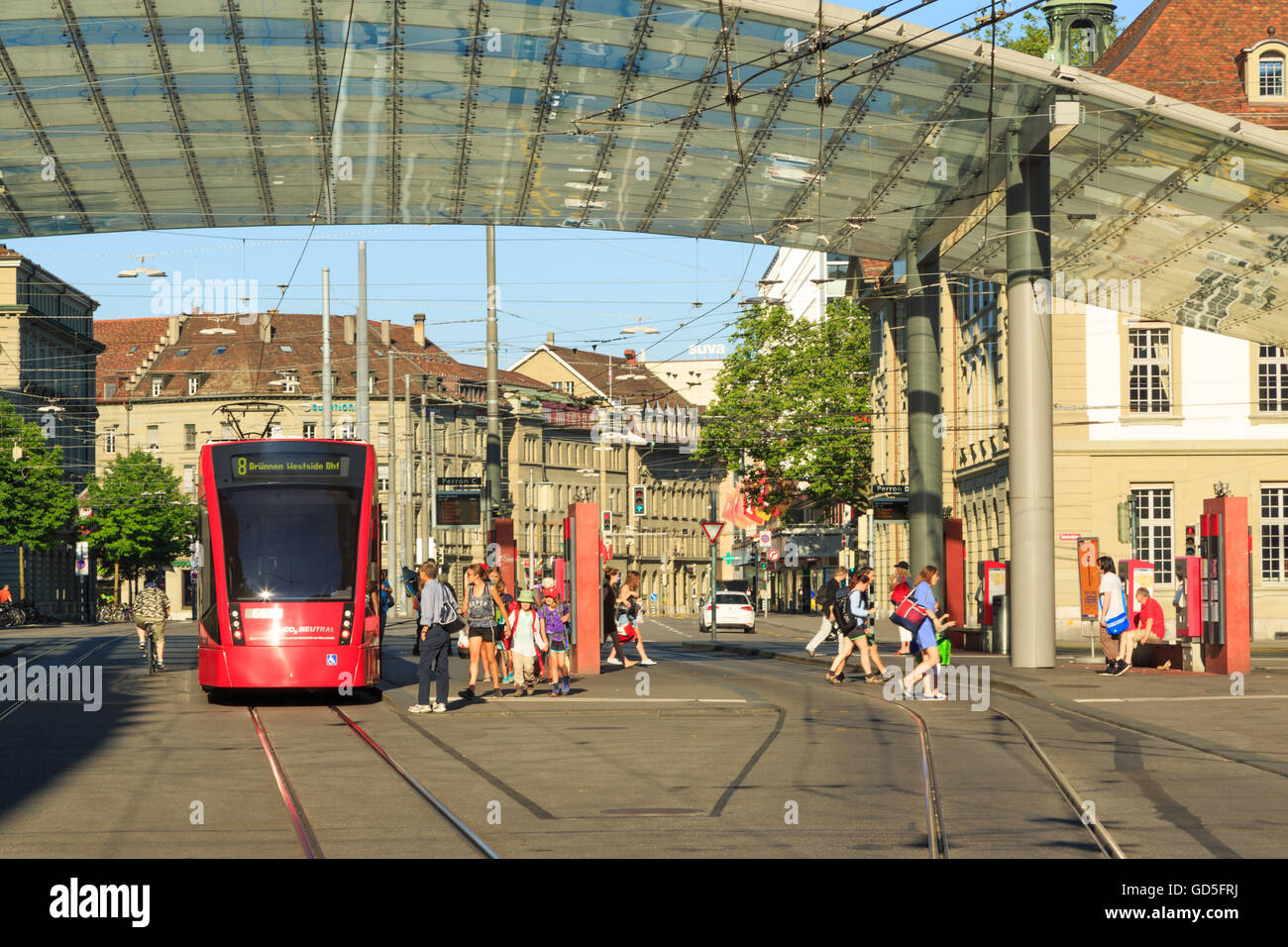 A photograph of a red tram near the main train station in Bern, Switzerland. Stock Photo