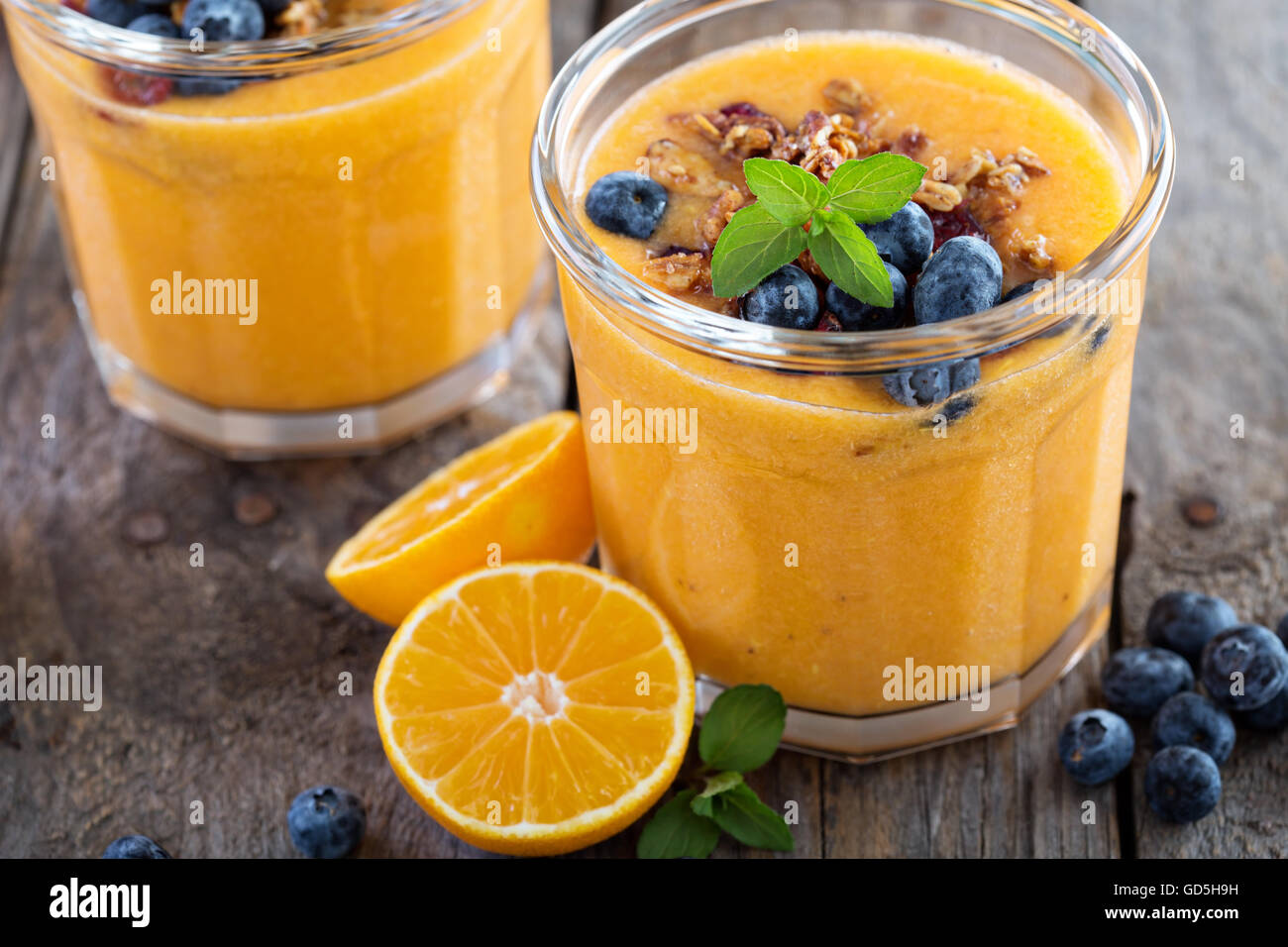 Orange and mango smoothie with granola Stock Photo