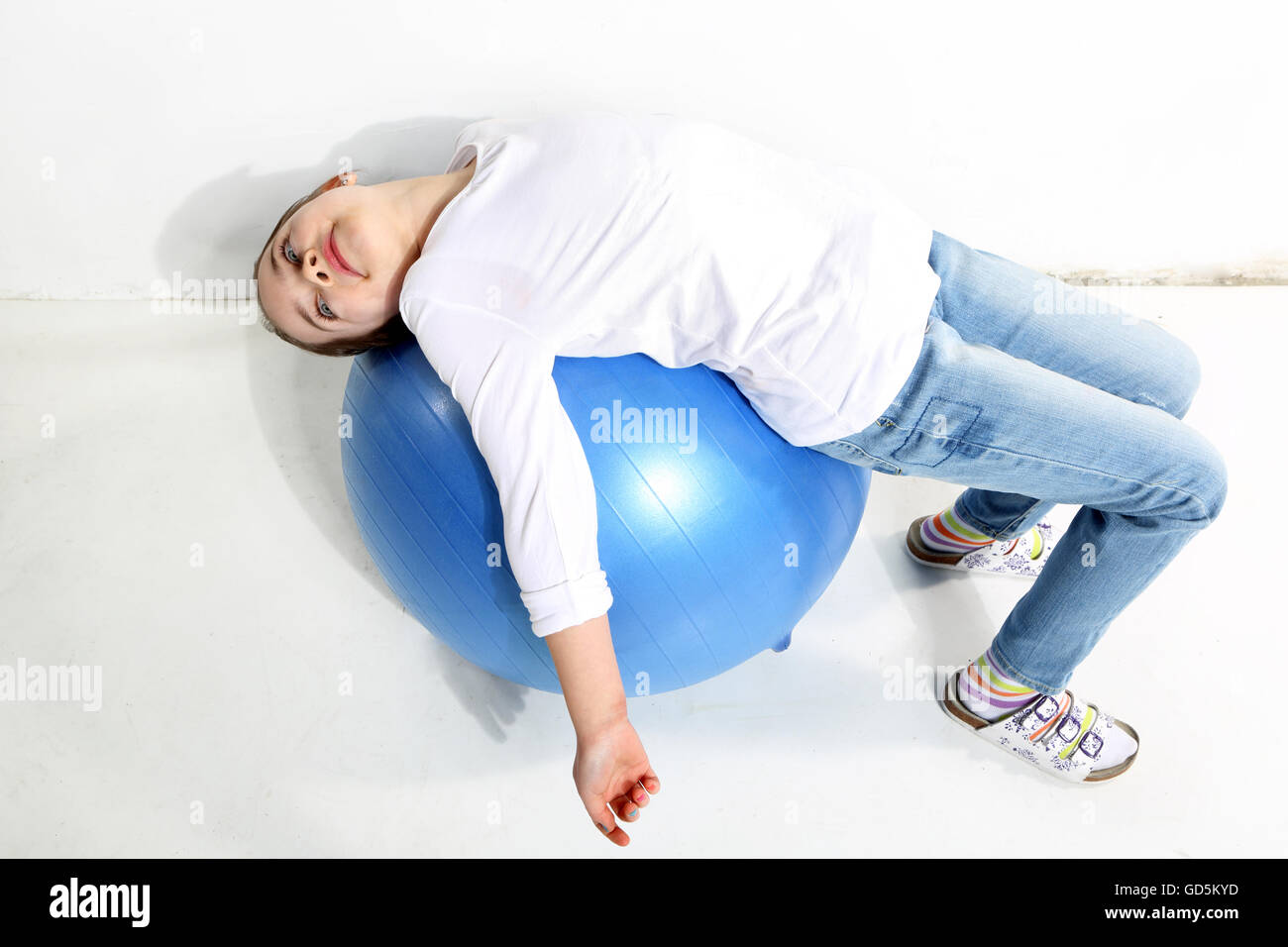 Little girl doing exercises with a rubber ball in studio Stock Photo