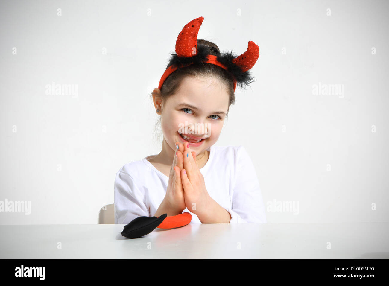 Little girl dressed as pretty imp in studio Stock Photo