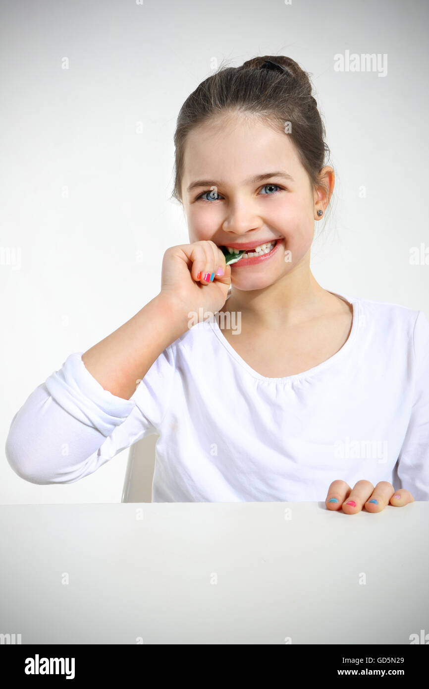 Little girl eating candy isolated on white Stock Photo Alamy