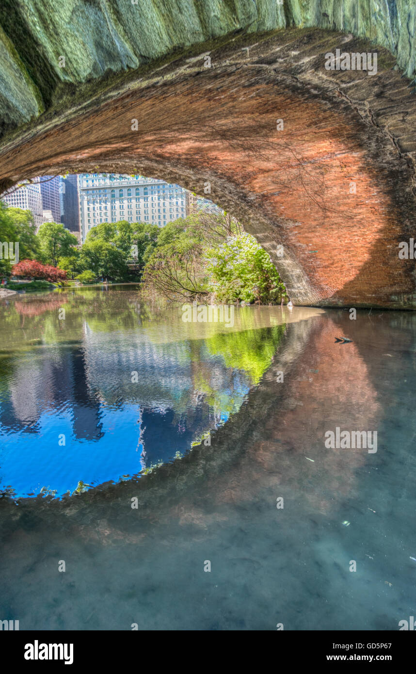 Gapstow Bridge arch reflected on the Central park pond, New York, NY