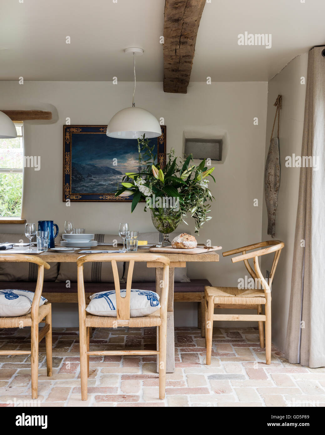 Antique oak dining chairs around rustic wooden table Stock Photo