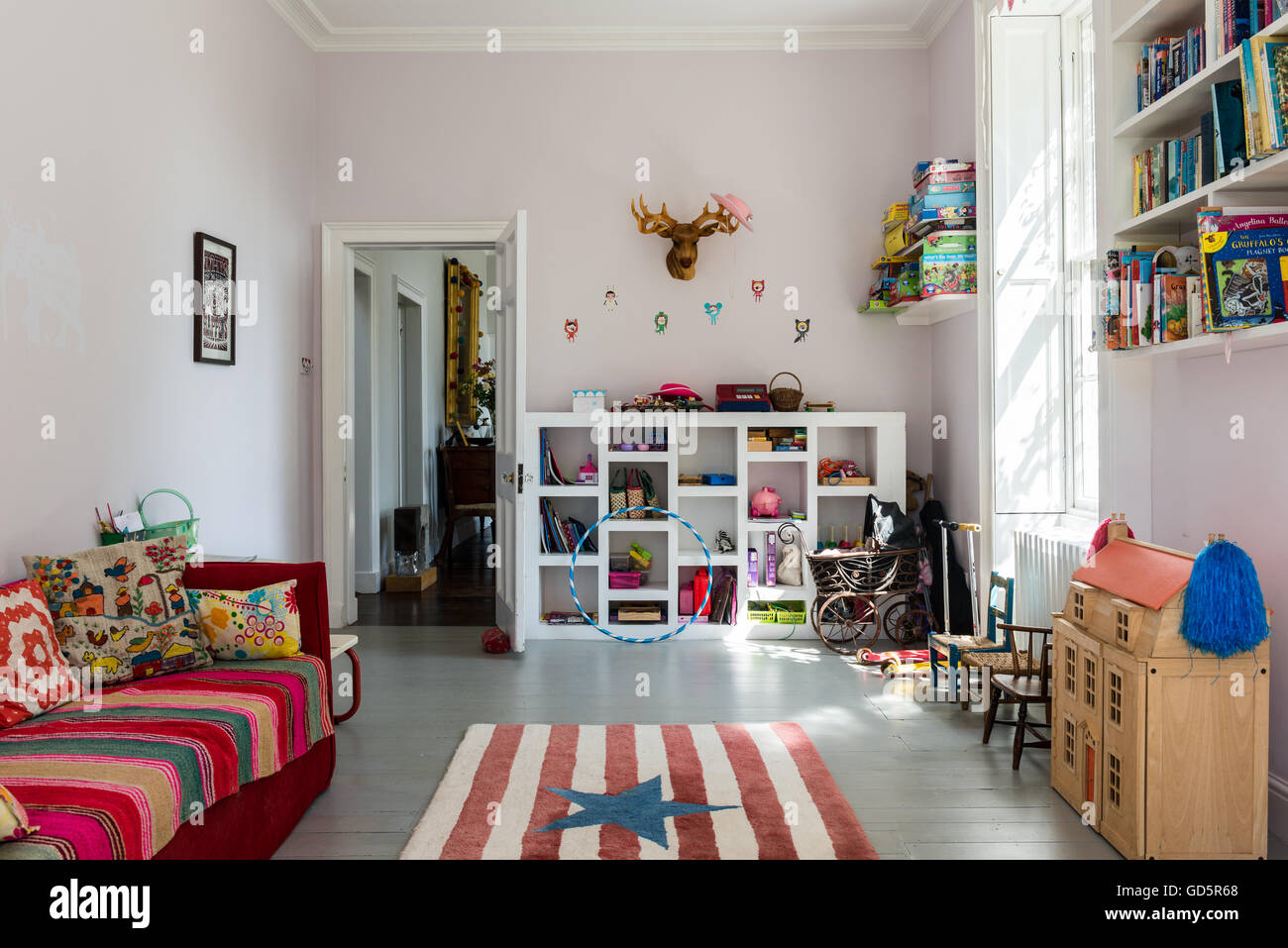 Childrens playroom with painted gray floorboards and stars and stripe rug Stock Photo
