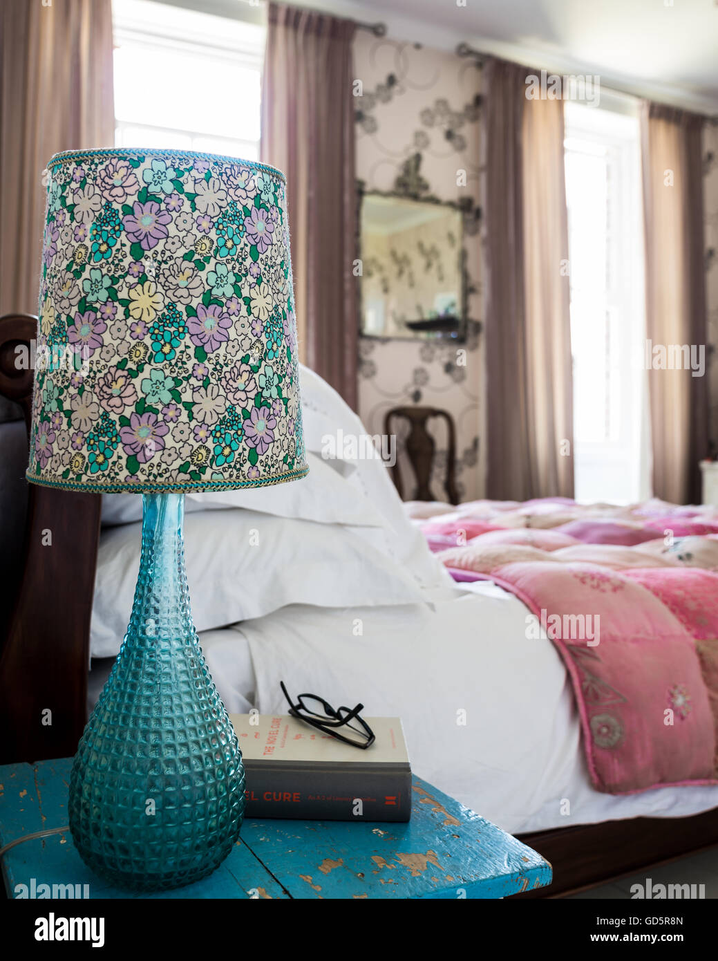 Modernist lamp with chintzy shade on bed side table Stock Photo
