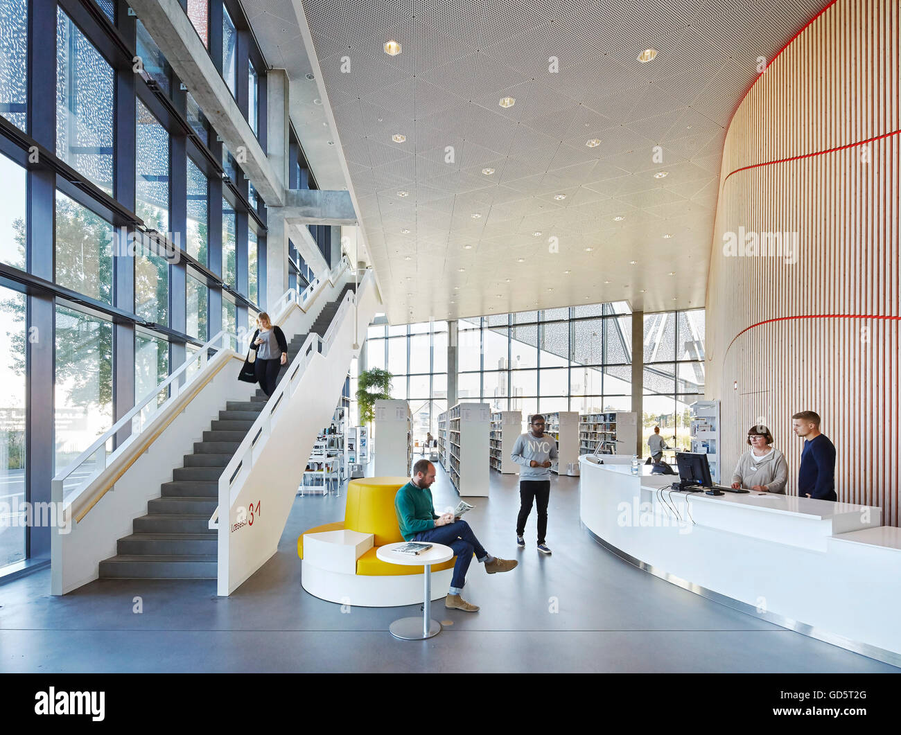 Ground floor foyer with library and reception desk. SDU Campus Kolding, Kolding, Denmark. Architect: Henning Larsen Architects, Stock Photo