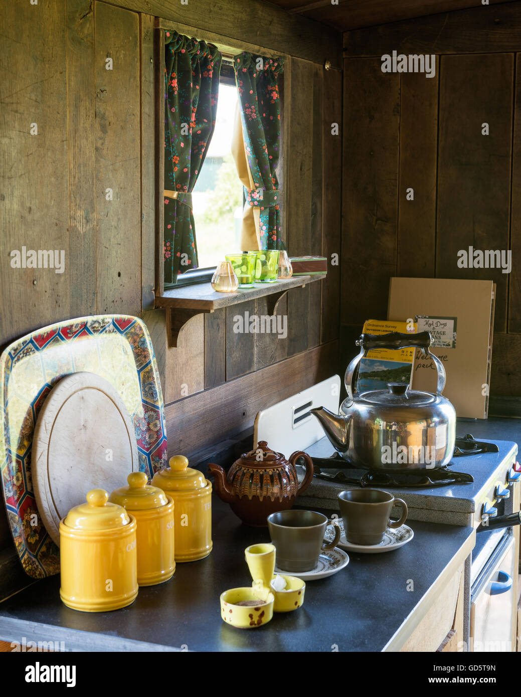 Wood clad kitchenette of converted military wagon with stive, kettle, and chintz details Stock Photo