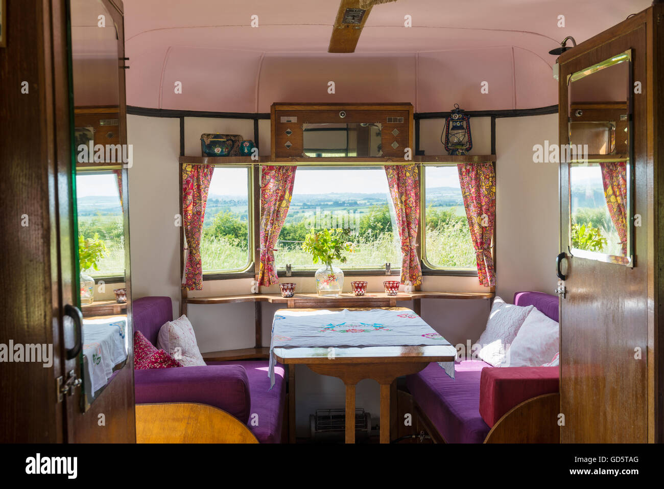 Seating area in caravan with retro style furnishings and coutryside views Stock Photo
