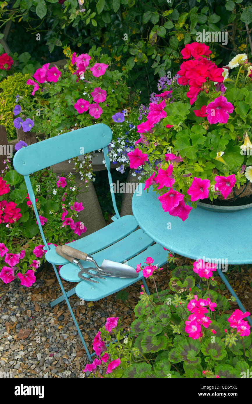 Cottage garden with container planting and blue table and chairs Stock Photo