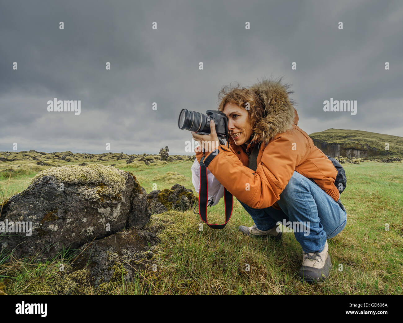 Female tourist taking pictures by, Orustuholl,  Iceland Stock Photo