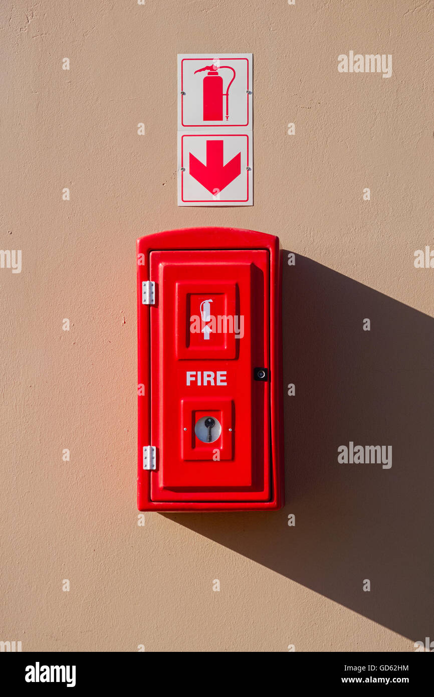 Red fire extinguisher box hanging on the wall Stock Photo