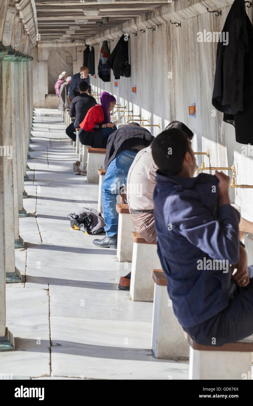 Muslims performing the ablution before entering the blue mosque for