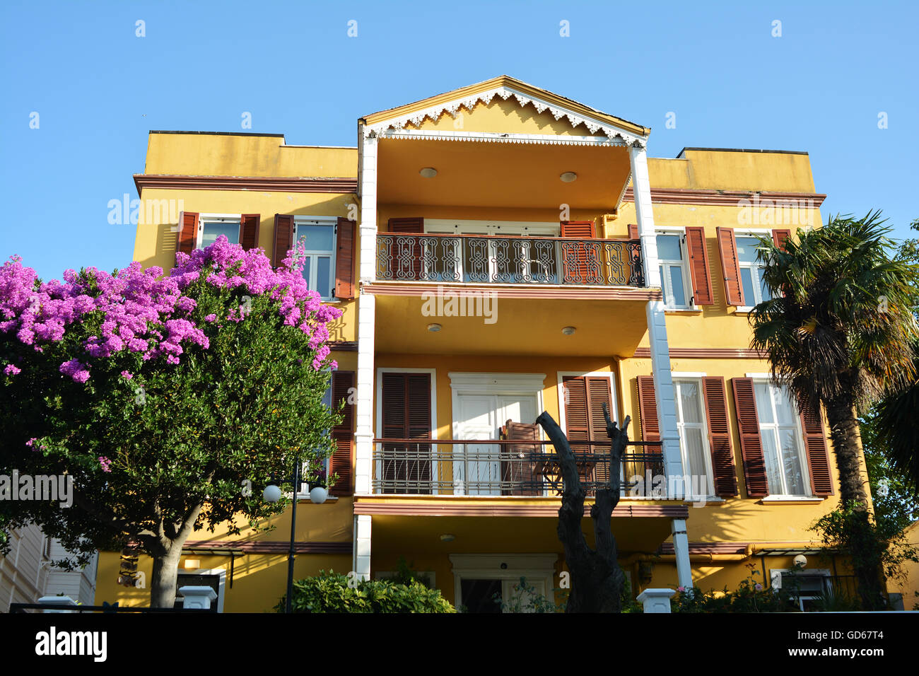 Yellow painted house with balconies and columns Stock Photo Alamy