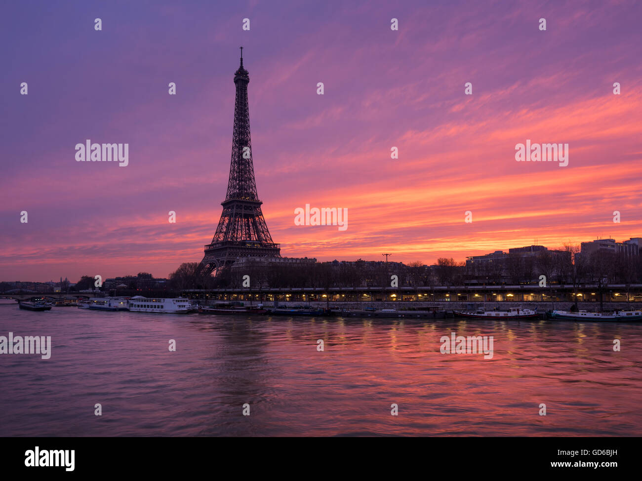 Fiery sunrise on the Eiffel Tower and Seine River with Port de Suffren, Paris (7th and 15th arrondissements) Stock Photo