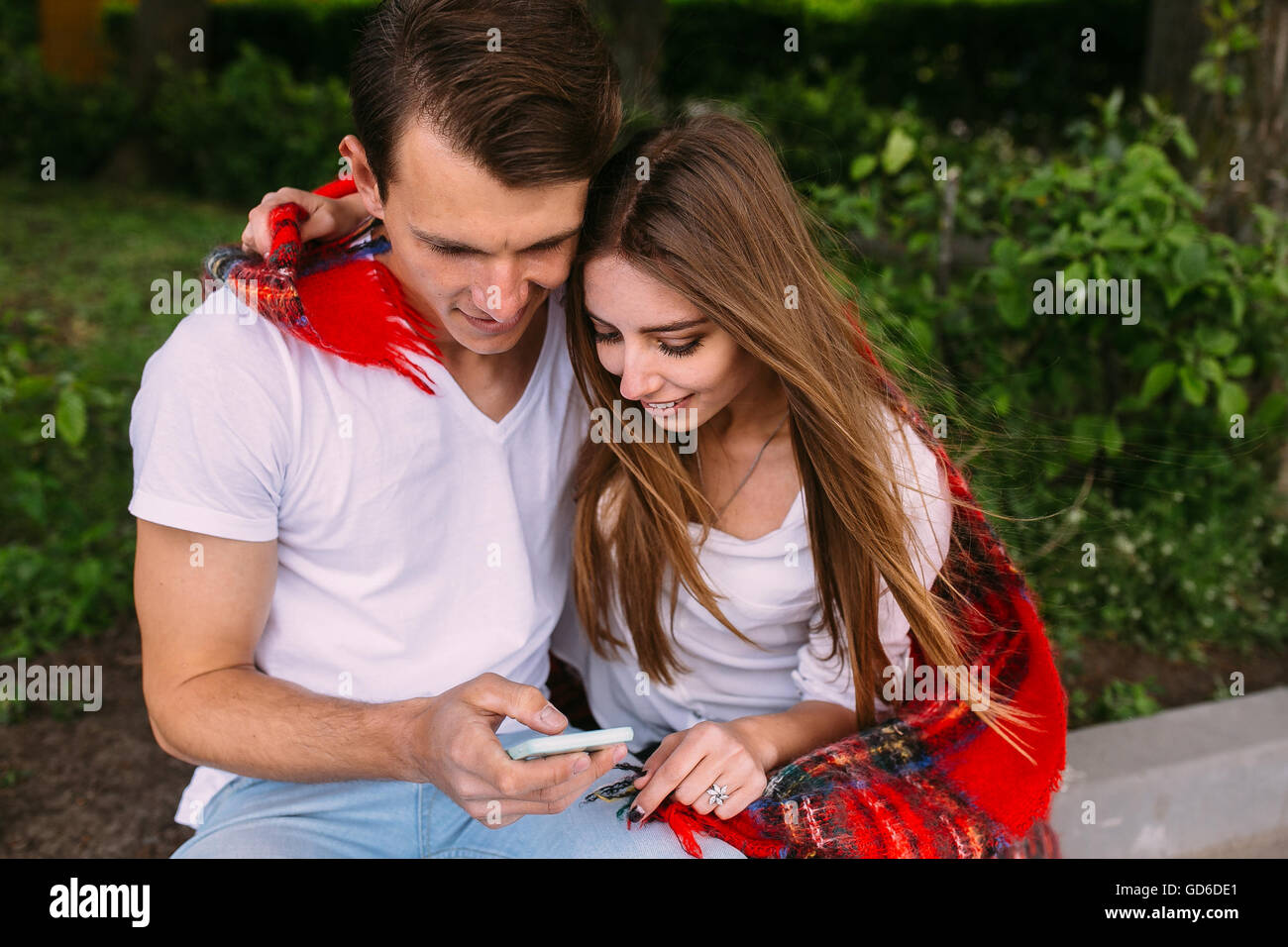 Beautiful young couple relaxing in the park Stock Photo - Alamy