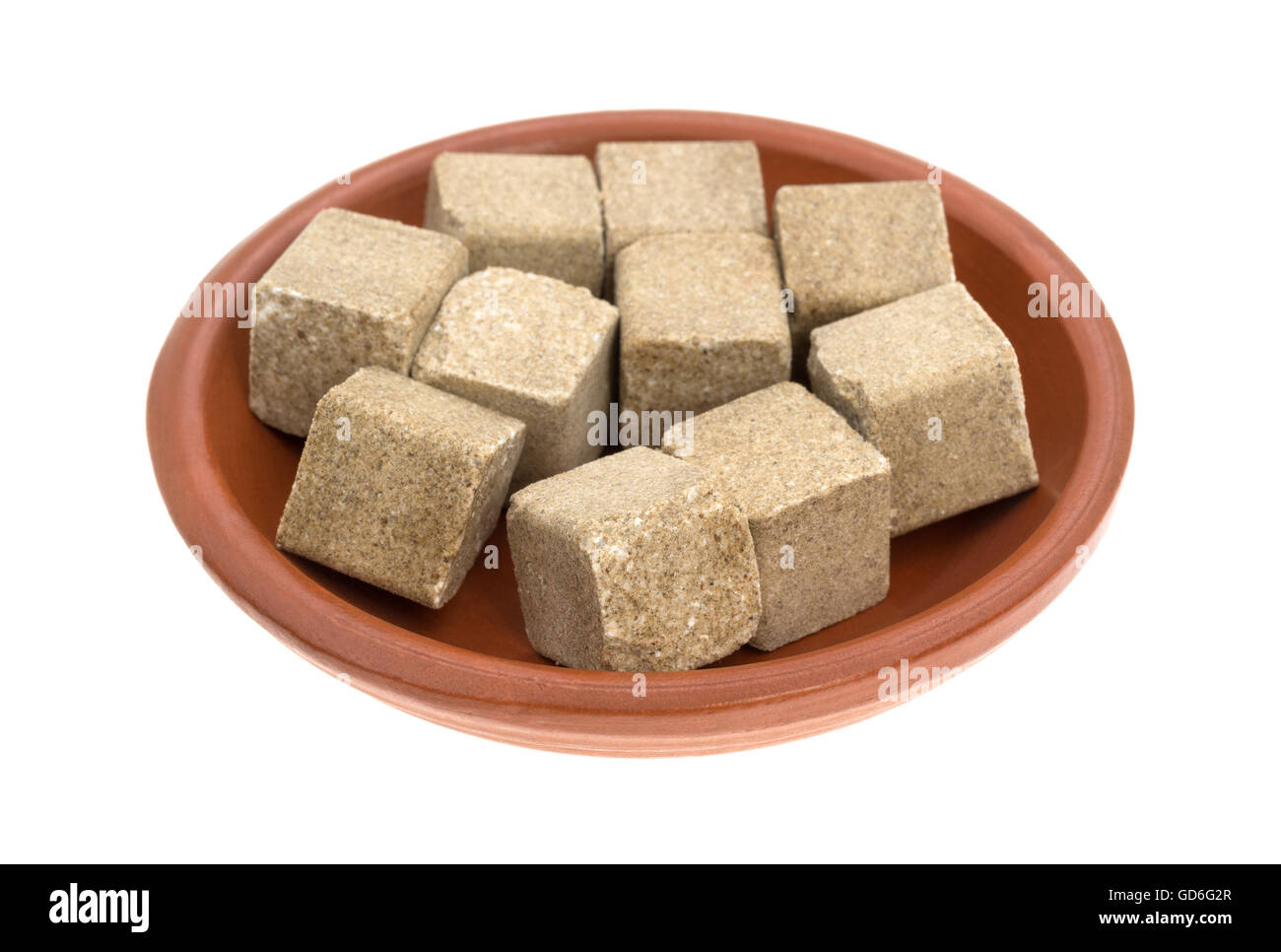 Several beef flavored bouillon cubes filling a small bowl isolated on a
