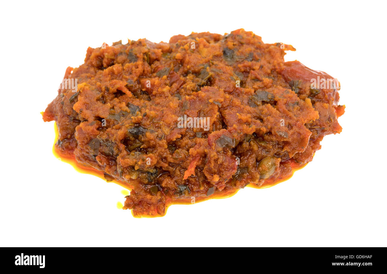 A small portion of tomato pesto sauce with sun dried tomatoes and pine nuts isolated on a white background. Stock Photo