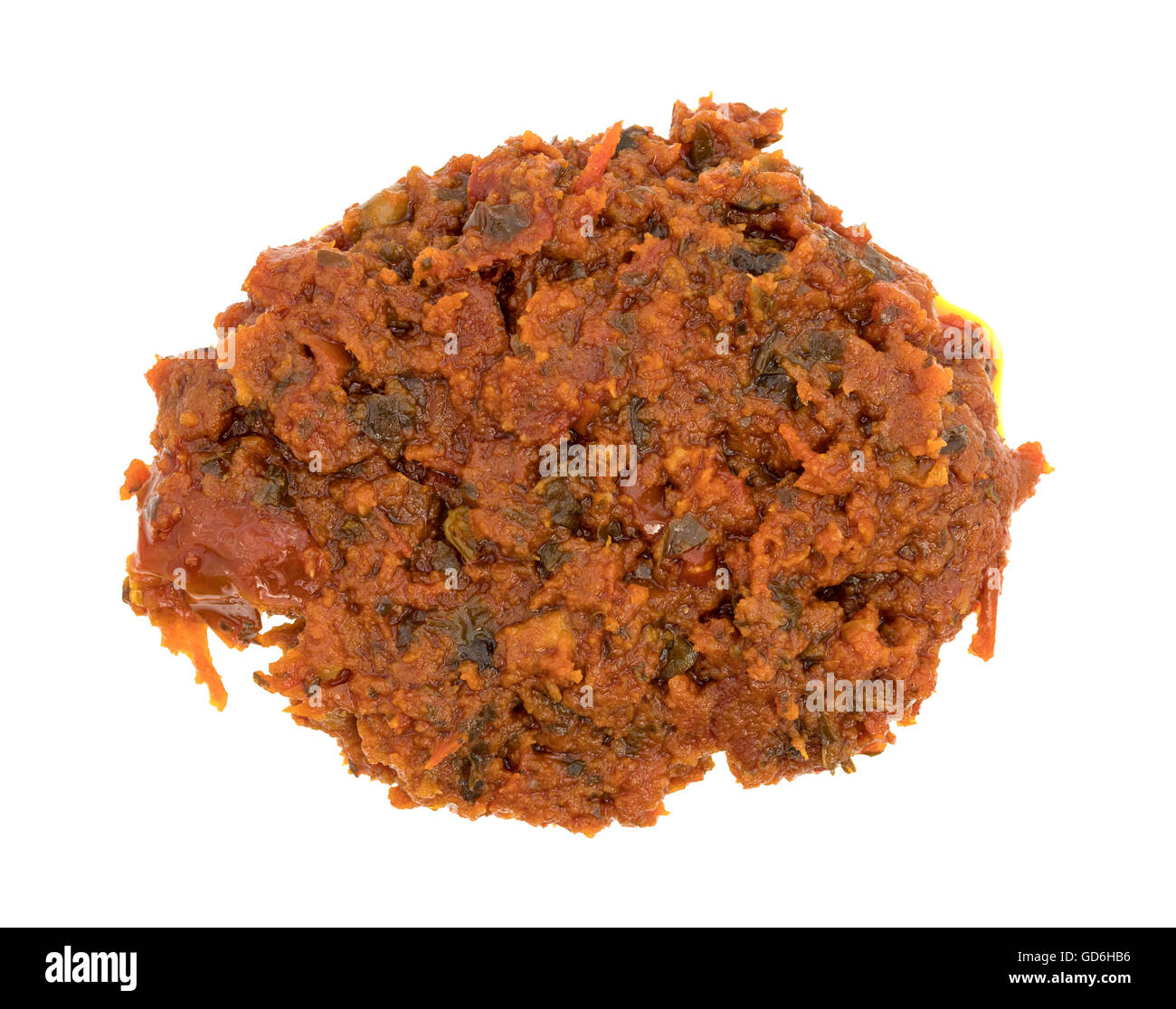 Top view of a small portion of tomato pesto sauce with sun dried tomatoes and pine nuts isolated on a white background. Stock Photo