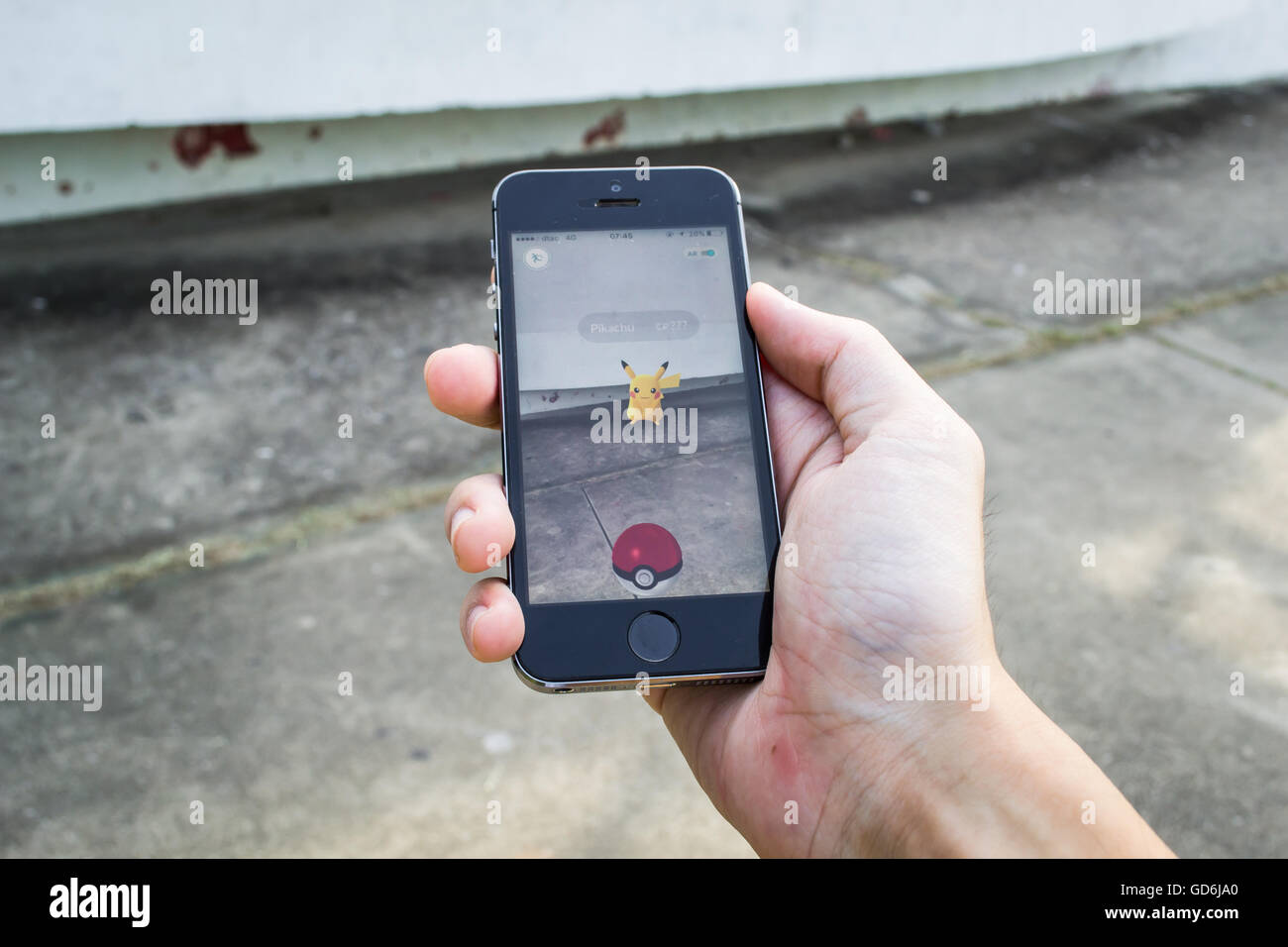 Bangkok, Thailand - July 12, 2016 : Apple iPhone5s held in one hand showing its screen with Pokemon Go application. Stock Photo